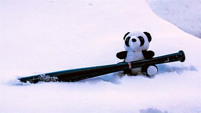 плюшевый панда с битой на снегу